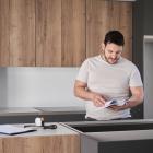 Argentinian man read instruction manual before installing kitchen furniture.