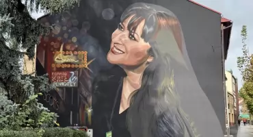 Basia Trzetrzelewska na muralu. Uśmiecha się do przechodniów